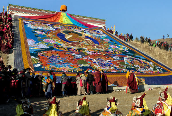 Monks and visitors pray around the portrait of a Budda on a huge tangka during a Tibetan Buddhism festival at the Labrang Monastery in Gansu province, Feb 22, 2013. Colorful celebration