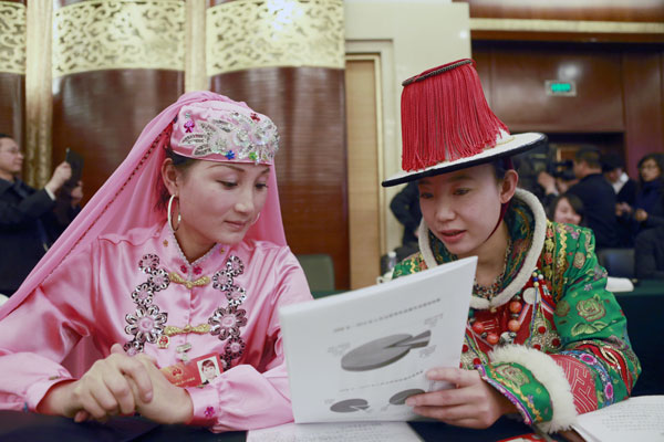 NPC deputy Chang Haixia (right), an assistant to the village chief at Xusanwan village in Gansu province, discusses the government report with her colleague Ma Xuehua. Feng Yongbin / China Daily Villagers draw inspiration from Xi