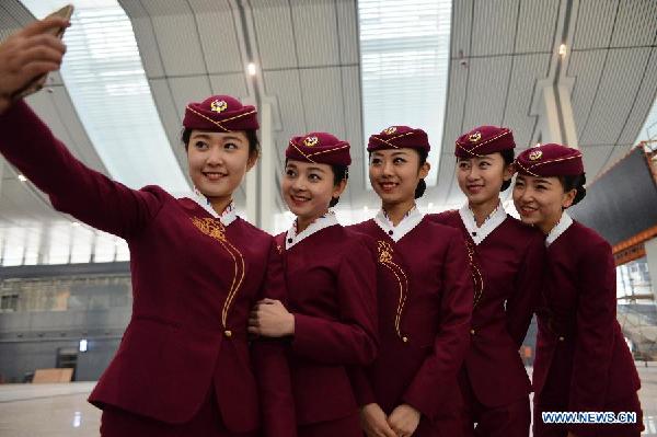 Staff members of the Lanzhou West Railway Station pose for a selfie in their new suit at the station in Lanzhou, capital of northwest China's Gansu Province, Dec. 2, 2014. Railway staff keep fashion on track