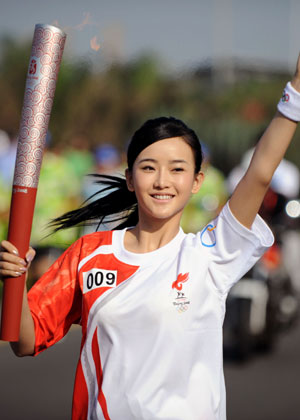 Torchbearer Han Yan runs with the torch during the 2008 Beijing Olympic Games torch relay in Haikou, south China's Hainan Province, on May 6, 2008. The Beijing Olympic torch relay in Haikou started at 8:10 a.m. on Tuesday at the Sea View Platform.