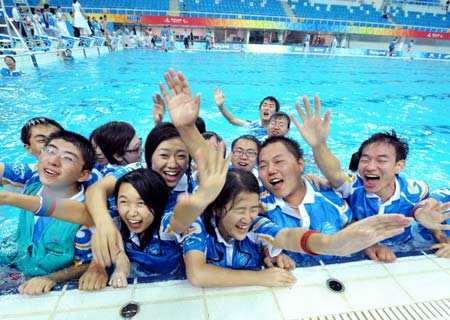 Volunteers jumps into the pool in the National Aquatics Center, or the Water Cube, in Beijing, China, Sept. 15, 2008.