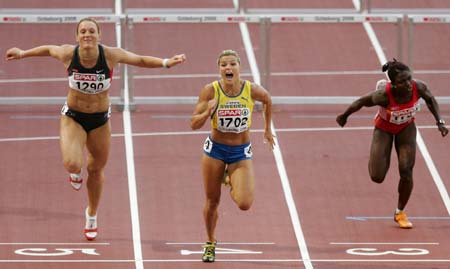 Sweden's Susanna Kallur (C) crosses the finish line to win the gold medal in the women's 100 m hurdles ahead of bronze medallist Kirsten Bolm of Germany (L) and Spain's Glory Alozie at the European athletics championships in Gothenburg (Goteborg), August 11, 2006.