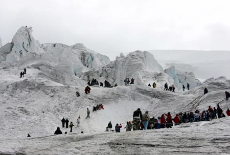 People walk along the slopes of the Cayambe volcano during the Ruta del Hielo (Ice Route) competition, 45 kilometres north of Quito, August 27, 2006. Participants carry blocks of glacial ice on their backs down the 5,790 meter-high volcano to the town. The annual competition evolved from the tradition of ice harvesting to make ice cream, a practice that died with the advent of electric ice-makers.
