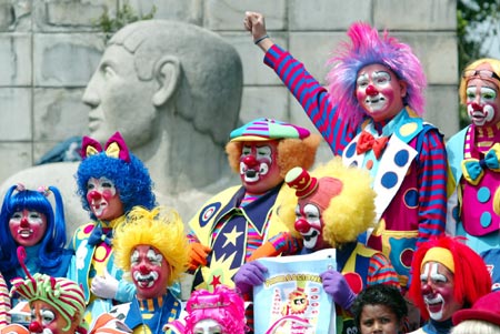 Clowns joke as they gather for a group photo at an international clown convention in Mexico City October 18, 2006. 