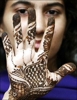 Patterns in henna : A Pakistani Muslim woman shows her hands, decorated with henna, in Lahore. 