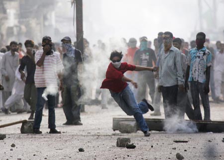 A protester returns a tear gas shell towards police during a protest against the killing of Baluch rebel chief Nawab Akbar Khan Bugti in Karachi August 30, 2006. Violent protests have erupted across Baluchistan province since Bugti was killed on Saturday in a government assault on his cave hideout in the remote hills of Pakistan's biggest but poorest province. 