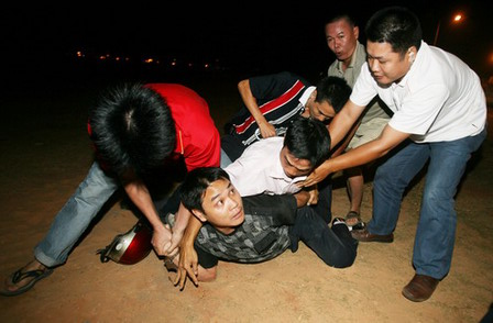 Rescuers stand on a capsized fishing boat in Qiongzhou Straight in South China's Hainan Province, January 17, 2006. The accident left six people missing. [Li Xiaogang/Southland Metropolis Daily]