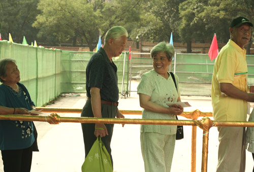 Residents wait to cast their votes on the demolishment and reconstruction of old buildings in Juixiaqiao Sub-district in Beijing, June 9, 2007. Local government and the real estate developer jointly organize the vote on Saturday to see if majority residents of over 5000 families accept the new compensation policy after failed attempts to reach an agreement through other ways. Both notary officials and supervisors are invited to monitor the vote that runs from 9 a.m. to 9 p.m. at six ballot booths. [Sun Yuqing/www.szjzcy.com]