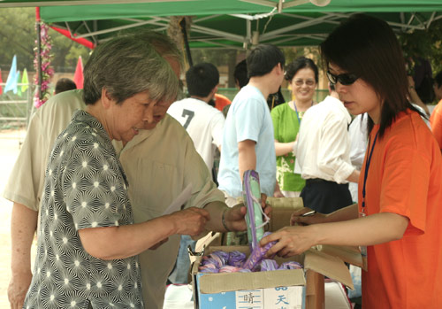 Voters choose the umbrella as a souvenir after voting on demolishment and reconstruction of old buildings in Juixiaqiao Sub-district in Beijing, June 9, 2007. Local government and the real estate developer jointly organize the vote on Saturday to see if majority residents of over 5000 families accept the new compensation policy after failed attempts to reach an agreement through other ways. Both notary officials and supervisors are invited to monitor the vote that runs from 9 a.m. to 9 p.m. at six ballot booths. [Sun Yuqing/www.szjzcy.com]