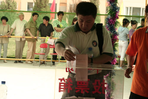 A voter casts his vote on demolishment and reconstruction of old buildings in Juixiaqiao Sub-district in Beijing, June 9, 2007. Local government and the real estate developer jointly organize the vote on Saturday to see if majority residents of over 5000 families accept the new compensation policy after failed attempts to reach an agreement through other ways. Both notary officials and supervisors are invited to monitor the vote that runs from 9 a.m. to 9 p.m. at six ballot booths. [Sun Yuqing/www.szjzcy.com]