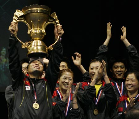 Chinese badminton team coach Lee Yong Bo (L) holds aloft the winner's trophy after the final of the Sudirman Cup World Team Badminton Championships in Glasgow, Scotland June 17, 2007.