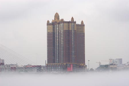 Buildings are seen in heavy fog in Jilin City, Northeast China's Jilin Province, August 12, 2007. [newsphoto]