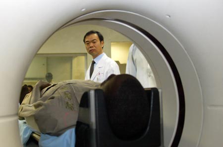 Chinese doctor Luan Chunmin looks at a patient under X-ray check at a hospital in Lusaka, Zambia, August 15, 2007. China now has 28 medical workers working at seven hospitals in Zambia in an effort to improve the local medical services. [Xinhua]