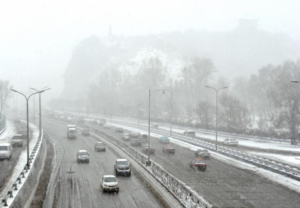 Vehicles move on a main road covered by melting snow in Urumqi, capital of Northwest China's Xinjiang Uygur autonomous region, April 4, 2011. Heavy snow hits Urumqi