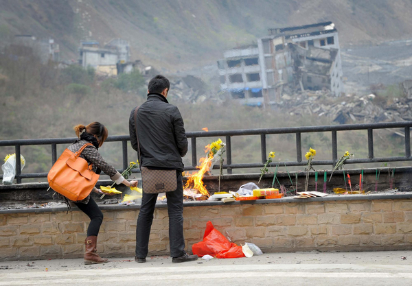 People mourn for the deceased in the old town of Beichuan Qiang autonomous county, Southwest China's Sichuan province, April 4, 2011. During the Qingming Festival, or the Tomb-sweeping Day, people come to the old town of Beichuan to mourn for those dead in the 8-magnitude earthquake in 2008. Beichuan quake victims mourned during Qingming Festival