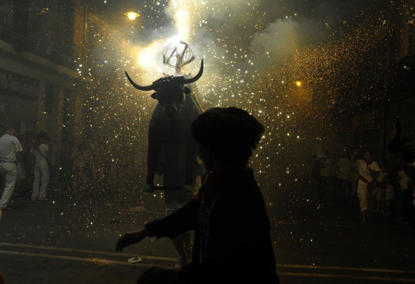 Revellers run from the 'Fire Bull', a man carrying a metal structure loaded with fireworks on the fifth day of the San Fermin festival in Pamplona July 11, 2011. Bulls run at San Fermin festival