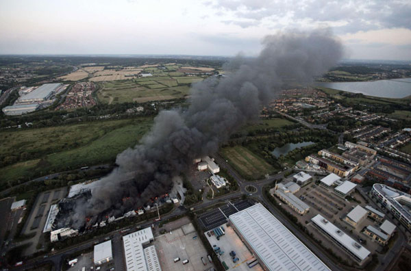 Smoke continues to rise from a Sony Warehouse which was destroyed by arsonists in Enfield in north London August 9, 2011. London scarred after riots