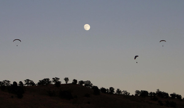 Paragliders sail above moon Paragliders sail above moon