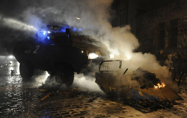 An armored vehicle of the German Police removes burning barricades during clashes at the so-called street party 'Schanzenfest' in the Schanze district in Hamburg August 20, 2011. Demonstrators clash with police in Hamburg