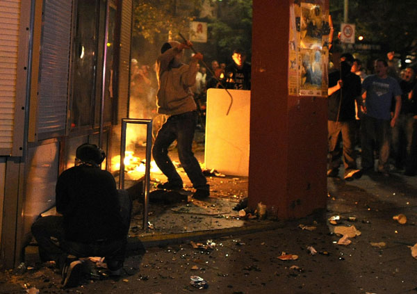 A demonstrator tries to gain entry into a bank during clashes at the so-called streetparty 'Schanzenfest' in the Schanze district in Hamburg August 20, 2011. Demonstrators clash with police in Hamburg