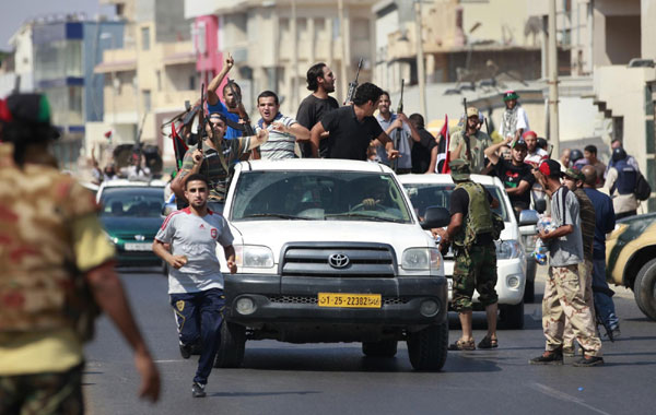 Libyan rebel fighters celebrate as they drive through Tripoli's Qarqarsh district August 22, 2011. Rebels seize Tripoli, inch toward victory