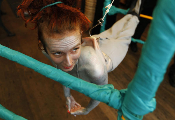 British performance artist Alice Newstead suspends from shark hooks pierced through her back at a cosmetic shop in San Francisco, California August 24, 2011.[ Hooked artist calls for shark protection