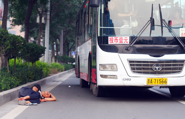 A man appears sound asleep on the side of the road in Taiyuan, capital of North China’s Shanxi province, Sept 7, 2011. Siesta time in N China
