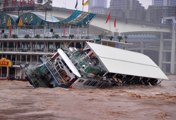 A floating restaurant capsizes after colliding with another ship in Jialing River, Southwest China’s Chongqing municipality, Sept 20, 2011. Dining ship swept by rushing river