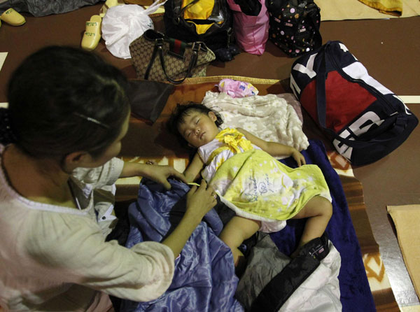 A woman takes care of her baby at an evacuation center in Nagoya after the area was flooded due to typhoon Roke, central Japan, September 20, 2011. Typhoon Roke lashes Japan, killing at least 6