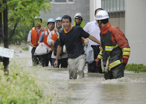 Residents walk in a flooded street to evacuate in Nagoya, central Japan, in this photo taken by Kyodo September 20, 2011. Typhoon Roke lashes Japan, killing at least 6