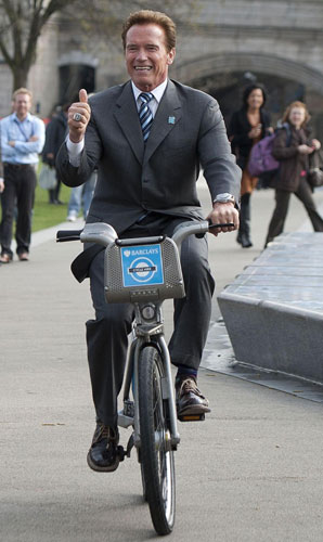 Arnold Schwarzenegger, former Governor of California poses gives a thumbs-up on a bicycle during a photo call in London, March 31, 2011. Politicians, celebrities promote 'green travel'