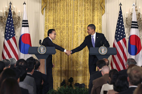US President Barack Obama (R) and South Korean President Lee Myung-bak shake hands during a joint press conference in the East Room of the White House, Oct 13, 2011. Obama, Lee hail long-sought trade deal