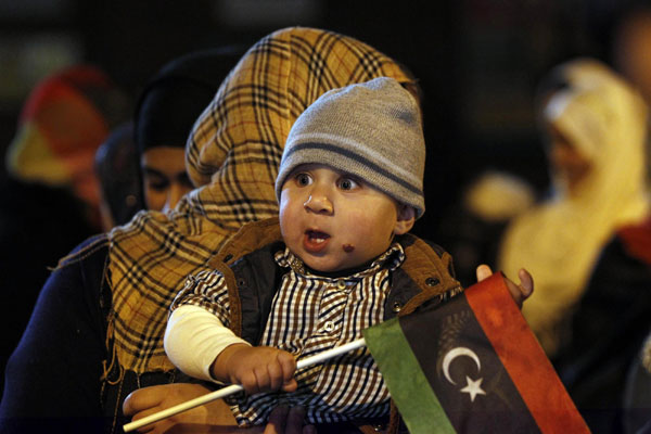 A child holds a Libyan flag as members of the Libyan community celebrate on the streets in the Rusholme area of Manchester, northern England Oct 20, 2011. Muammar Gadhafi was killed by Libyans, succumbing to wounds, some seemingly inflicted after his capture by fighters who overran his last redoubt on Thursday in his hometown of Sirte. Libya people celebrate as Gadhafi killed