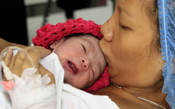 Filipina mother Camille kisses her newborn baby girl named Danica Camacho, the Philippines' symbolic 'seven billionth baby' who is part of the United Nations' seven billion global population projection, in Fabella Maternity hospital in Manila Oct 31, 2011. Seven billionth baby born in Philippines
