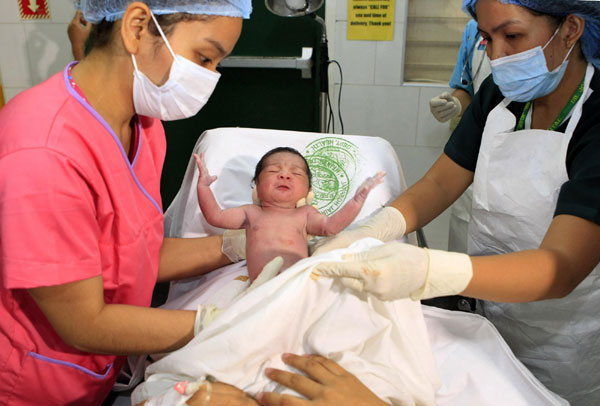 Midwives hold a newborn baby girl named Danica Camacho, the Philippines' symbolic 'seven billionth baby' who is part of the United Nations' seven billion global population projection, in Fabella Maternity hospital in Manila Oct 31, 2011. Seven billionth baby born in Philippines