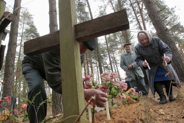 People light candles at their relative's grave at a cemetery in the village of Ivenets, some 50 km (31 miles) southwest of Minsk, Nov 1, 2011. Catholics in Belarus marked All Saints Day on Tuesday by visiting the graves of their relatives. People memorize deceased on All Saints Day