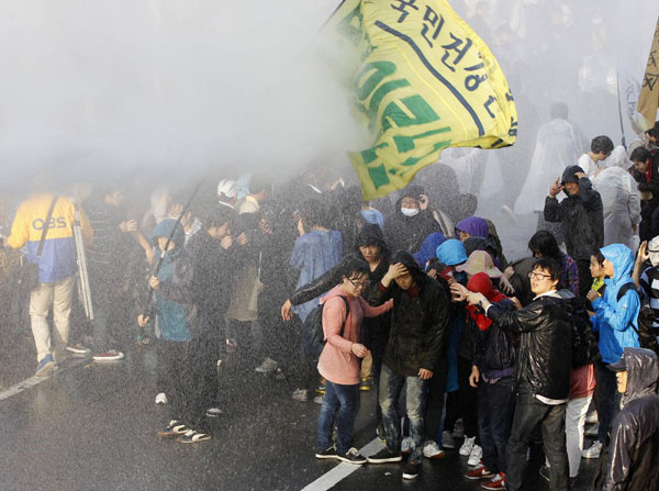 Protesters are hit by water cannons used by the police as they try to enter the National Assembly during a rally against the South Korea-US free trade agreement (FTA) talks in Seoul Nov 3, 2011. South Koreans protest free trade agreement with US