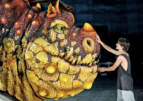 Rarmian Newton, who plays the lead role of 'Hiccup', touches Gronckle, a dragon from the live entertainment event 'How To Train Your Dragon Arena Spectacular' in Sydney on Tuesday. Beginning its global tour in Australia in March 2012, high-flying, fire-brathing dragons will be brought to life in this epci arena adventrue which is inspired by the Academy Award nominated DreamWorks animation film How To Train Your Dragon. Training the dragon