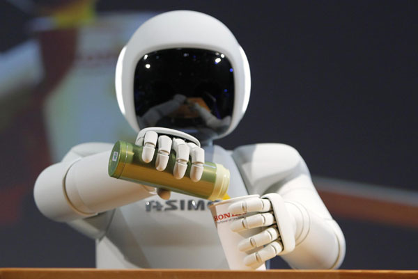 Honda Motor Co's Asimo humanoid robot pours a drink into a cup during a news conference at the 42nd Tokyo Motor Show in Tokyo November 30, 2011. Tokyo Motor Show kicks off
