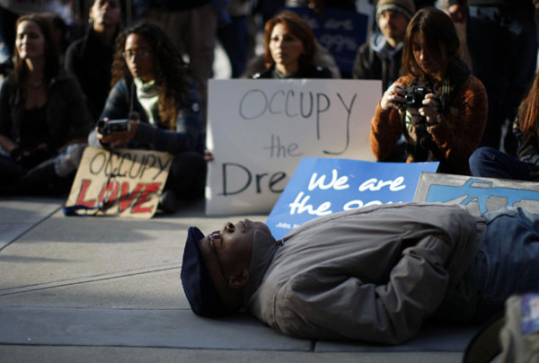 Activists with Occupy Los Angeles and African American faith and clergy community members pray as they come together to hold an Occupy the Dream rally in honor of American civil rights icon Dr. Martin Luther King outside the Los Angeles Federal Reserve Bank offices on Martin Luther King Day in Los Angeles, California January 16, 2012. Martin Luther King Day marked in US