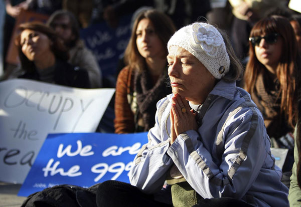 Activists with Occupy Los Angeles and African American faith and clergy community members pray as they come together to hold an Occupy the Dream rally in honor of American civil rights icon Dr. Martin Luther King outside the Los Angeles Federal Reserve Bank offices on Martin Luther King Day in Los Angeles, California January 16, 2012. Martin Luther King Day marked in US