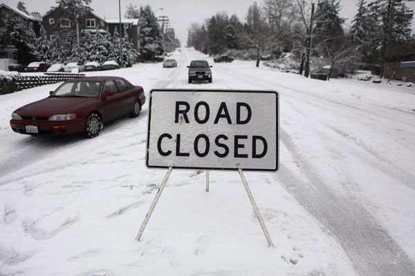 Vehicles ignore a road closure on a hill in Kirkland, Washington as the northeast was hit with a snowstorm January 18, 2012. Washington braced for epic snowstorm
