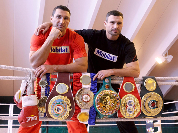 Ukranian heavyweight boxers Vladimir (L) and his brother Vitali Klitschko pose with their world championship titles belts during a photo call at their training camp in Austria. Mighty brothers show off trophy before fight