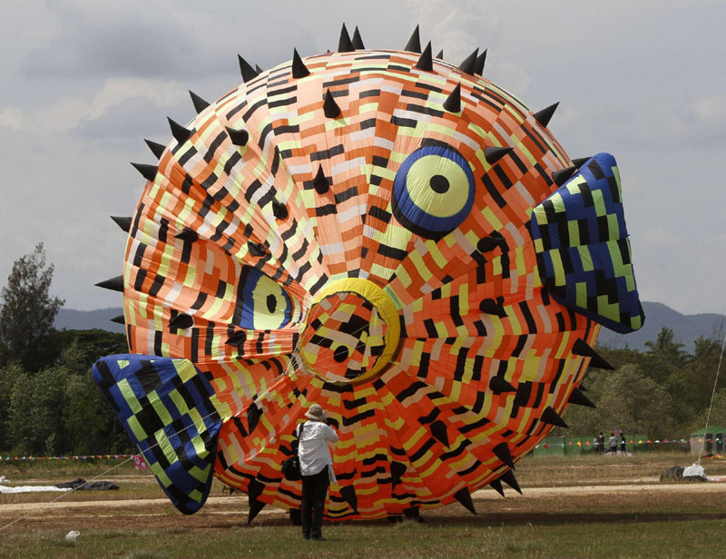 A man takes photographs of a globefish-shaped kite during the Cha-Am International Kite Festival at the Thai resort beach town of Cha-Am, 160 km (99 miles) southwest of Bangkok, March 10, 2012. Kite festival kicks off in Thailand