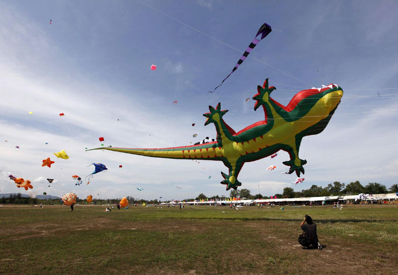 A man takes photographs of a crocodile-shaped kite during the Cha-Am International Kite Festival at the Thai resort beach town of Cha-Am, 160 km (99 miles) southwest of Bangkok, March 10, 2012. Kite festival kicks off in Thailand