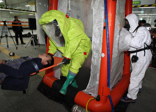 Rescuers carry a man out during an anti-terrorism drill at a subway station in Seoul March 20, 2012, which was held in a preparation for the Seoul Nuclear Security Summit from March 26-27 Anti-terrorism drill held in Seoul ahead of summit