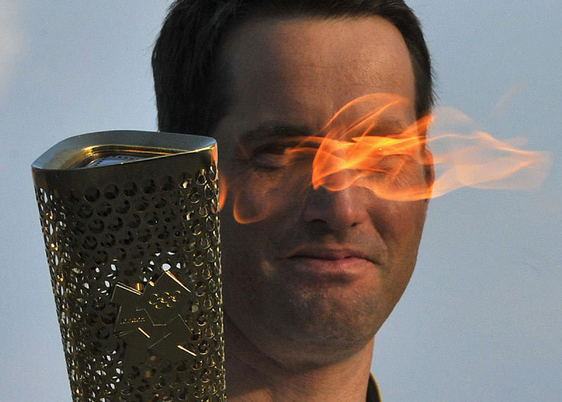 British Olympic sailor Ben Ainslee carries the Olympic torch on the first leg of its Britain, Northern Ireland and Ireland tour at Lands End in Cornwall, southwest England, May 19, 2012. 2012 Sports Photos in Review: Moments at London Games