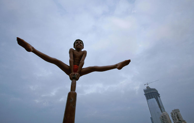 A boy performs a Mallakhamb pose on a pole at the Shree Samartha Vyayam Mandir in Mumbai, on Oct 21, 2012. 2012 Sports Photos in Review: Off the court