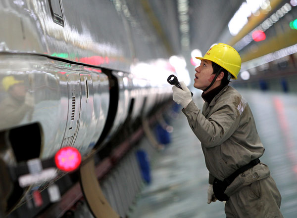 A technician uses a flashlight to check the power supply unit of a bullet train in Shanghai on Dec 19, 2012, as part of an overhaul launched by the Shanghai Railway Bureau to all bullet trains that will be used to transport passengers during the upcoming Spring Festival travel rush, which is expected to last two weeks around the festival. Bullet trains get check-ups before travel rush