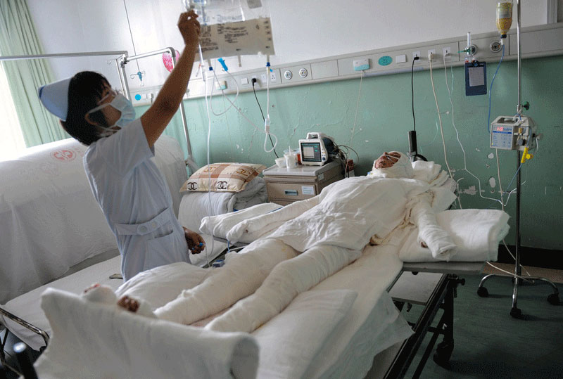 A man who saved a couple from a burning farmhouse after a gas leak sparked an explosion is treated in the ICU of Taizhou Hospital. Heroes of 2012